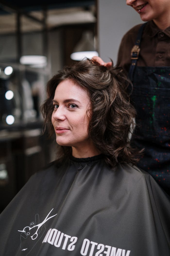 Woman enjoying a stylish haircut at a contemporary salon, showcasing a joyful experience.